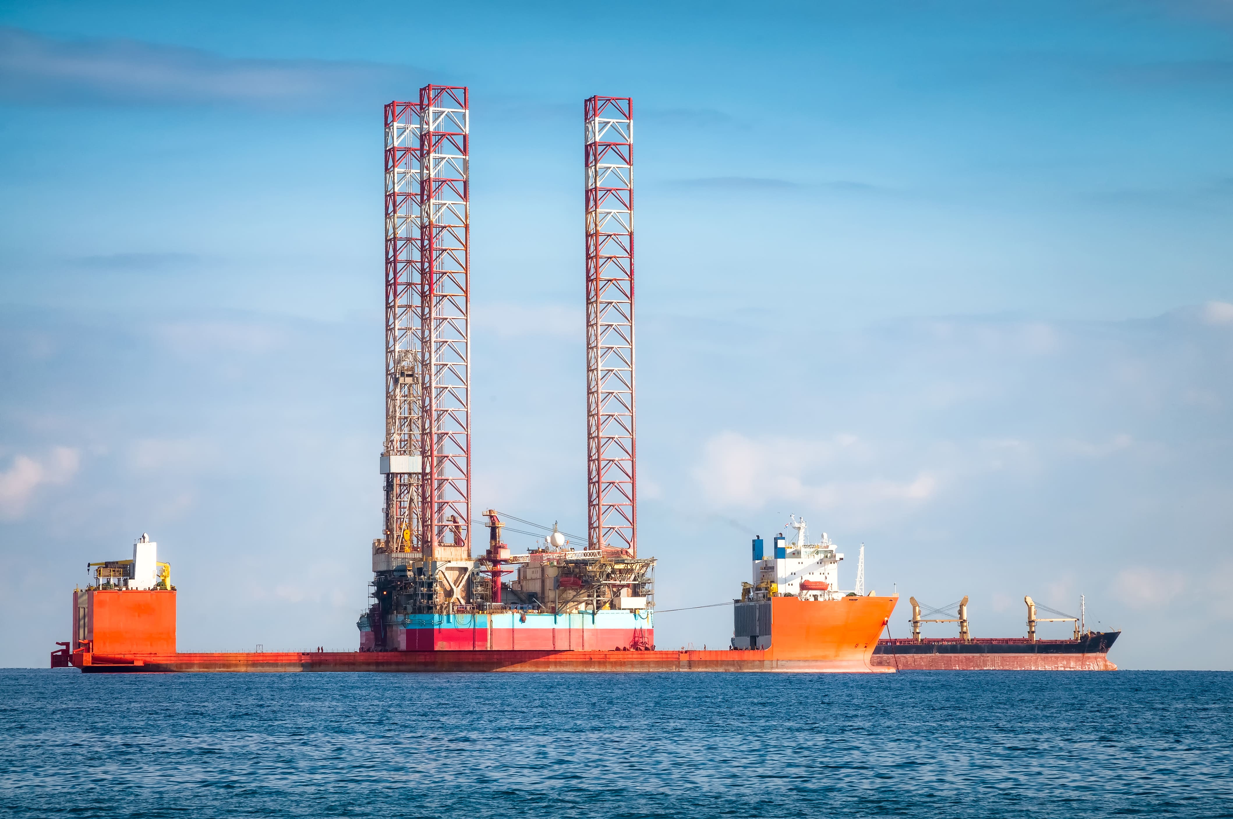 A close-up front view of an oil and chemical carrier causing a spray as it navigates the ocean.